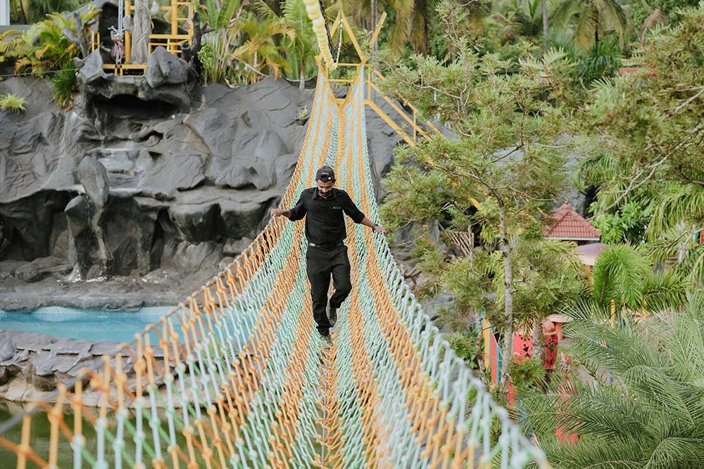 Visitor crossing a rope bridge at Arco Park ’N’ Resort, Kasaragod